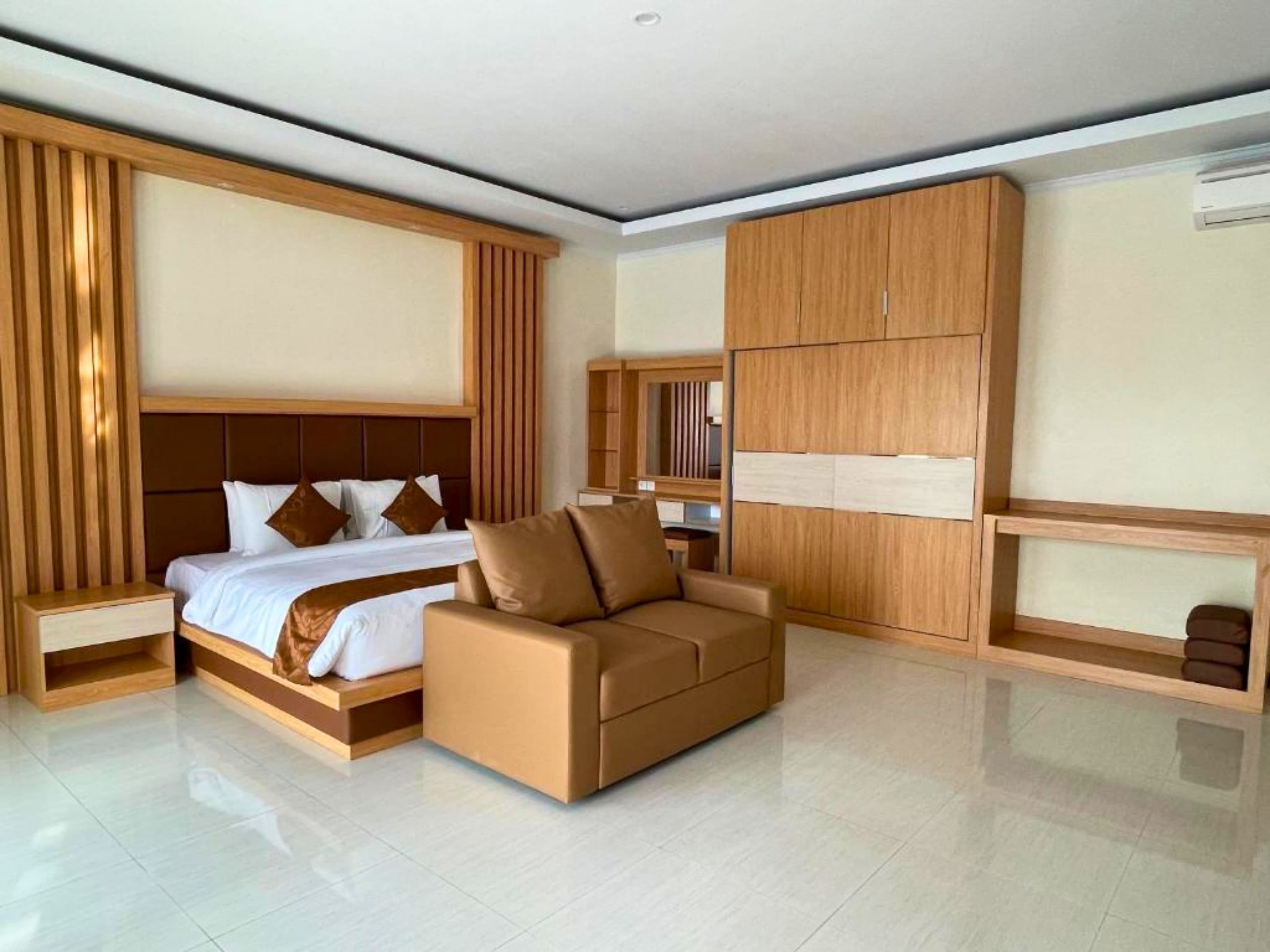 Two-Bedroom Villa — main bedroom with king bed and leather sofa